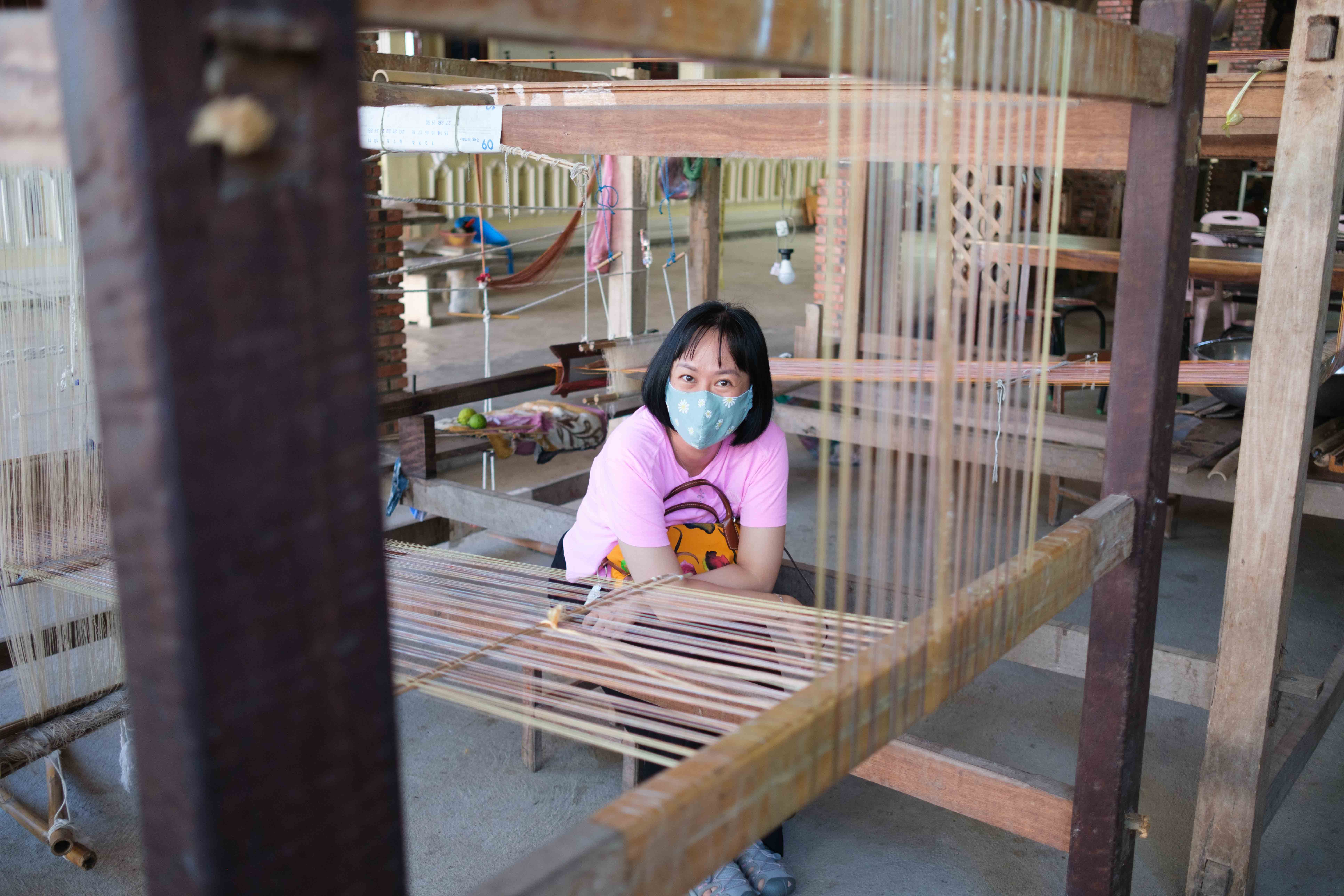 Nguyen Thi Hoang Anh sat beside a traditional weaving machine