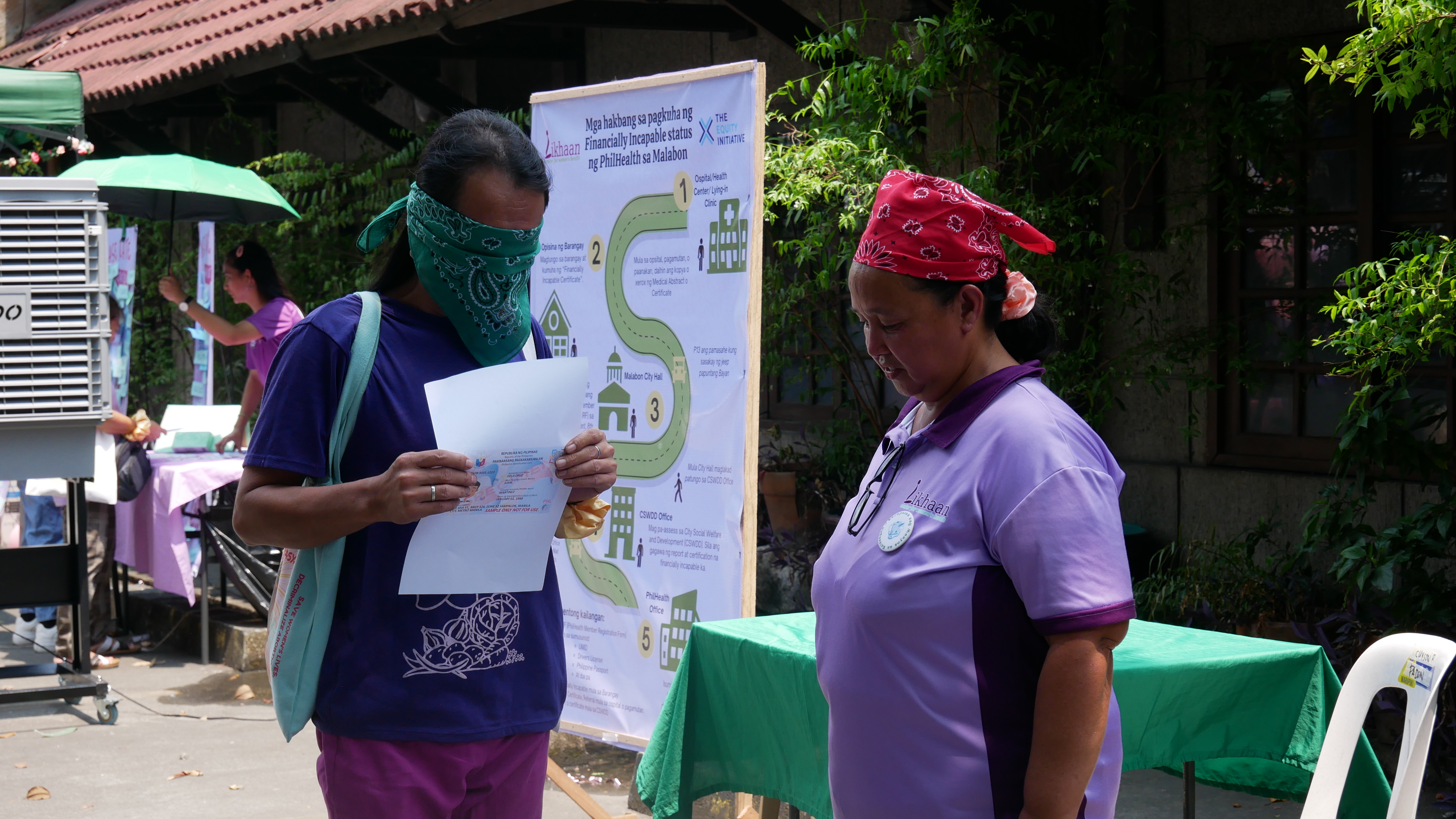 8 Likhaan Community Organizer assists a participant about to begin obstacle route to availment of PhilHealth benefit.JPG